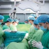 Doctors observe a minute of silence to pay tribute to the organ donor. (Photo: published by VNA)