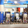 Motorcycle riders refill their vehicles at a petrol station in Hanoi (Photo: VNA)