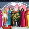 Ambassador Nguyen Dac Thanh presents flowers to President of the Vietnamese Businesswomen Association in Europe Trinh Thi Mui. (Photo: VNA) 