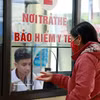 A resident in Lao Cai province registers for medical examination and treatment using health insurance card at a local health centre. (Photo: VNA) 