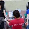 Young people donate blood at a voluntary blood donation event. (Photo: VNA)