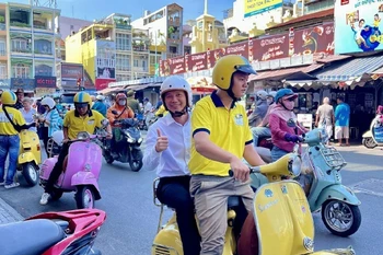 Tourists enjoy exploring Ho Chi Minh City by Vespa. (Photo: VNA)