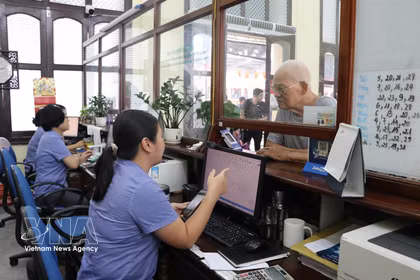 Staff at Hai Phong Railway Station assist passengers with ticket purchase procedures (Photo: VNA)