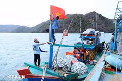 Fishermen prepare their vessels before setting sail, ensuring compliance with fishing regulations. (Photo: VNA)
