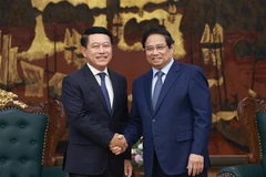 Prime Minister Pham Minh Chinh (R) receives Saleumxay Kommasith, Politburo member, Deputy Prime Minister and head of the Lao People’s Revolutionary Party (LPRP) Central Committee’s Commission for State-owned Enterprise (SOE) Reform. (Photo: VNA)