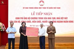 President of the Vietnam Fatherland Front (VFF) Central Committee Do Van Chien receives the token of 82 billion VND from Governor of the State Bank of Vietnam Nguyen Thi Hong. (Photo: VNA)