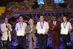 The organisers present scholarships to students with outstanding academic achievements. (Photo: VNA)