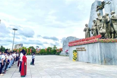 The Vietnam Summer Camp delegation lays flowers at the Monument of President Ho Chi Minh and the people of Quang Binh at Ho Chi Minh Square in Dong Hoi ward, Quang Tri Province. (Photo: VNA)