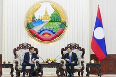 Lao Prime Minister Sonexay Siphandone (R) hosts a reception for Prosecutor General of the Supreme People’s Procuracy of Vietnam Nguyen Huy Tien. (Photo: VNA)