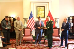 VFW representative (L) hands over wartime memorabilia to the Vietnamese side. (Photo: VNA)
