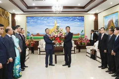 Vietnamese Ambassador Nguyen Minh Tam presents flowers from Party General Secretary To Lam to congratulate the 70th anniversary of the Lao People's Revolutionary Party. (Photo: VNA)