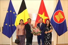 Lao Ambassador to Belgium Kingphokeo Phommahaxay (left) presents congratulation flowers to Vietnamese Ambassador Nguyen Van Thao on August 26. (Photo: VNA)