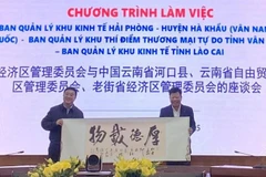 A leader of Hekou county (Yunnan, China) presents a souvenir to Le Trung Kien (R), head of the Hai Phong Economic Zone Authority. (Photo: VNA)