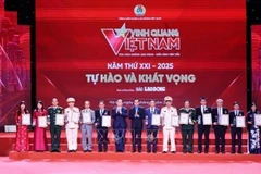 Head of the Party Central Committee’s Commission for Information, Education and Mass Mobilisation Nguyen Trong Nghia (seventh from left), and President of the Vietnam General Confederation of Labour Nguyen Dinh Khang (eighth from left) present the Glory to Vietnam 2025 emblems and certificates to the honoured collectives. (Photo: VNA)