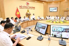 Minister of Industry and Trade Nguyen Hong Dien (standing) chairs a working session with major Vietnamese enterprises on May 7. (Photo: VNA)