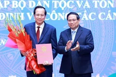 Prime Minister Pham Minh Chinh presents the appointment decision to Dao Ngoc Dung as Minister of Ethnic and Religious Affairs. (Photo: VNA)