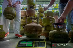 A man weighs a 3 kg LPG cylinder during a surprise inspection in Lumajang, East Java. (Photo: Antara)