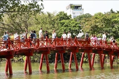 Tourists at The Huc Bridge, a popular spot in in the heart of Hanoi. (Photo: VNA)