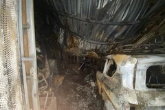 A car is burned down to its frame and left in the courtyard of the apartment complex. (Photo: VNA)
