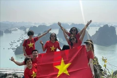 Tourists excited after conquering the peak of Bai Tho Mountain. (Photo: VNA)