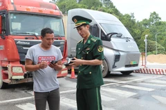 A Lang Son border guard examines a truck driver's documents at Huu Nghi International Border Gate. (Photo: VNA)