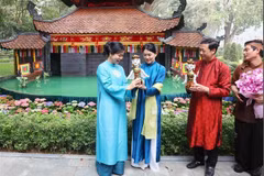 Madam Ngo Phuong Ly (L) presents a water puppet to Madam Loo Tze Lui. (Photo: VNA)