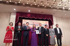 Assoc. Prof. Dr. Nguyen Duc Son presents the decision establishing the Vietnamese Language Proficiency Test Council in Japan to a representative of the Vietnam Studies Centre in Japan. (Photo: VNA)