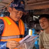 A working team from Coast Guard Region 2 Command inspects fishing licences and vessel monitoring system and guides fishermen on compliance with IUU fishing regulations. (Photo: VNA)