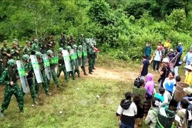 In the simulated scenario, Lao Bao International Border Gate Station (Vietnam) coordinates with Border Company 320 (Laos) to set up checkpoints and conduct public information campaigns to prevent free migration and illegal cross-border movements. (Photo published by VNA) 