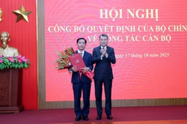 Politburo member, Secretary of the Party Central Committee, and head of its Organisation Commission Le Minh Hung (R) presents flowers to congratulate Nguyen Van Phuong. (Photo: VNA) 