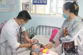 A doctor at Ho Chi Minh City Children's Hospital 1 examines a child with measles. (Photo: VNA)