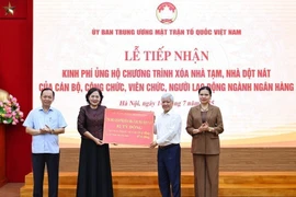 President of the Vietnam Fatherland Front (VFF) Central Committee Do Van Chien receives the token of 82 billion VND from Governor of the State Bank of Vietnam Nguyen Thi Hong. (Photo: VNA)
