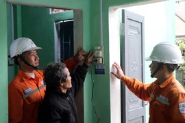 The Kon Tum power sector accompanies the Quang Trung Campaign by providing support, installing, inspecting and guiding residents on the safe use of electrical equipment as they move into their new homes. (Photo: VNA)