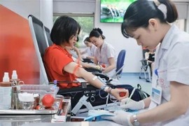 Volunteers participate in blood donation at the event. (Photo: VNA)