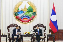 Lao Prime Minister Sonexay Siphandone (R) hosts a reception for Prosecutor General of the Supreme People’s Procuracy of Vietnam Nguyen Huy Tien. (Photo: VNA)