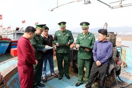 Officers and soldiers of Quynh Phuong Border Guard Station disseminate regulations on fisheries exploitation to local fishermen. (Photo: VNA)