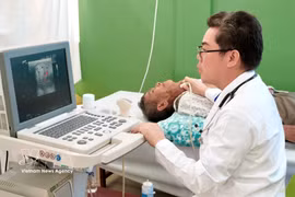 Dr Ton Thanh Tra, Director of Cho Ray–Phnom Penh Hospital, personally examines and performs an ultrasound for a critically ill patient, who was later admitted for free surgery at the hospital. (Photo: VNA)