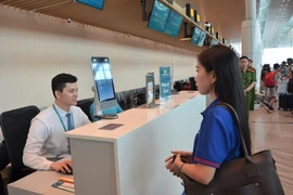 A passenger undergoes facial biometric recognition during the check-in process. (Photo: VNA)