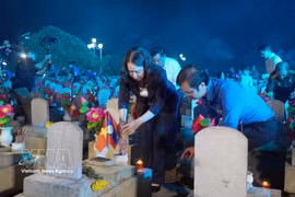 Vice State President Vo Thi Anh Xuan offers incense at the graves of fallen soldiers at the Vietnam–Laos Martyrs' Cemetery. (Photo: VNA)