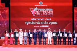 Head of the Party Central Committee’s Commission for Information, Education and Mass Mobilisation Nguyen Trong Nghia (seventh from left), and President of the Vietnam General Confederation of Labour Nguyen Dinh Khang (eighth from left) present the Glory to Vietnam 2025 emblems and certificates to the honoured collectives. (Photo: VNA)