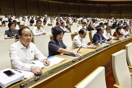 National Assembly deputies vote to adopt a resolution on amending and supplementing several articles of the 2013 Constitution on May 5. (Photo: VNA) 