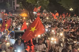 People take to Hanoi streets waving the national flag in celebration of the victory. (Photo: VNA)