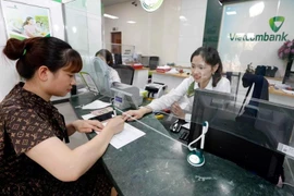 Customer conducting transactions at Vietcombank Hanoi. (Photo: VNA)