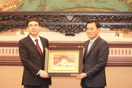 Vice Chairman of the Ho Chi Minh City People’s Committee Bui Xuan Cuong presents a gift to the Guangzhou delegation. (Photo: VNA)