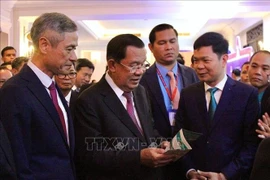 President of the Cambodian Senate Samdech Techo Hun Sen visits booths showcasing Vietnamese enterprises operating in Cambodia as part of the ceremony. (Photo: VNA)