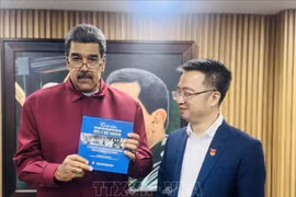 Venezuelan President Nicolas Maduro receives the Spanish edition of "The world's affection for President Ho Chi Minh" from Nguyen Tuong Lam, Secretary of the Ho Chi Minh Communist Youth Union Central Committee. (Photo: Vietnamese Embassy in Venezuela)