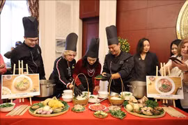 International friends experience how a bowl of pho is prepared. (Photo: VNA)