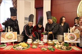 International friends experience how a bowl of pho is prepared. (Photo: VNA)