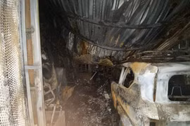 A car is burned down to its frame and left in the courtyard of the apartment complex. (Photo: VNA)