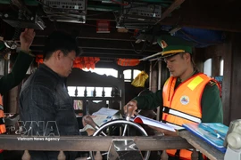 Border guards inspect and verify fishing vessels’ documents and procedural records before departure. (Photo: VNA)